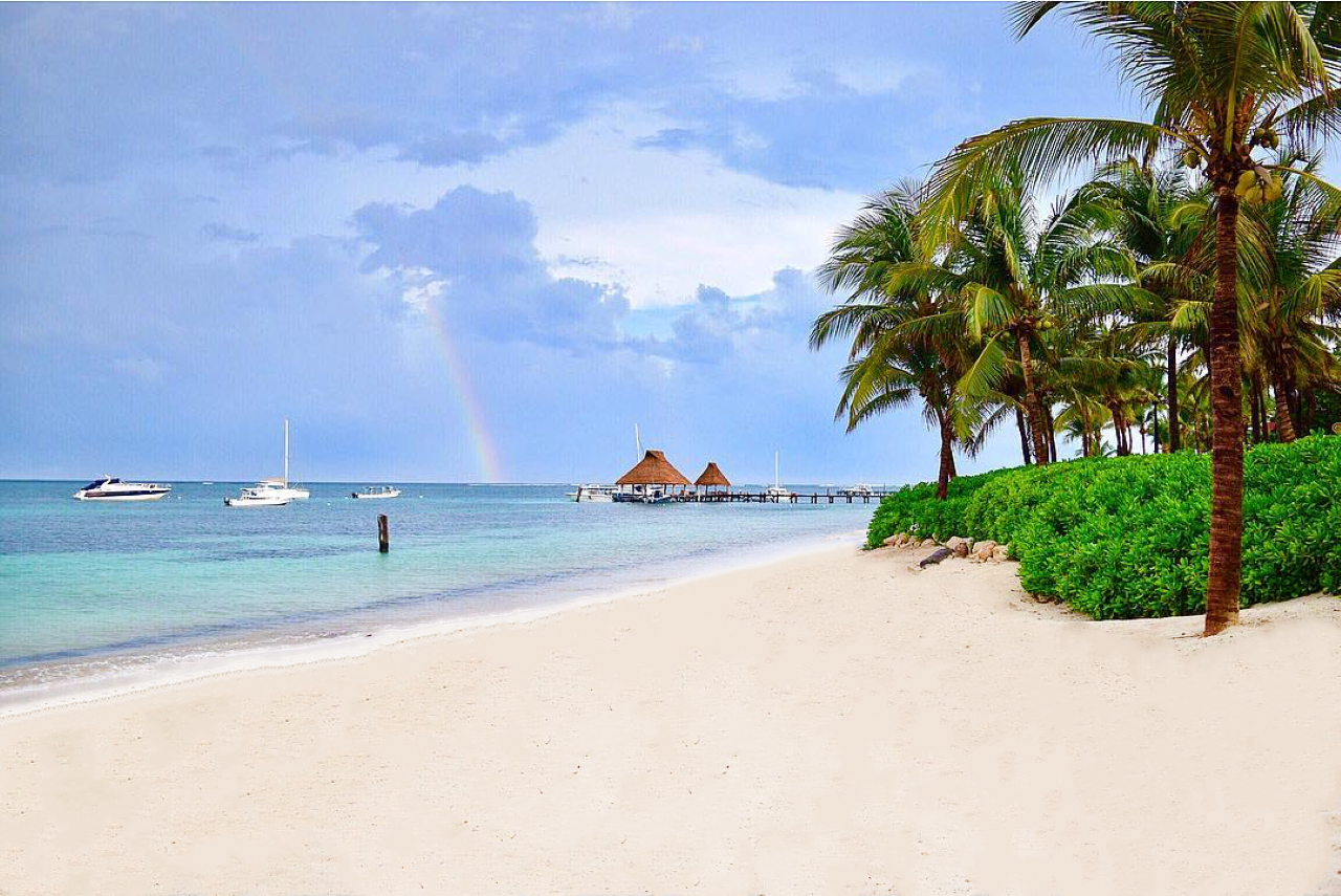 Blue water white sand beach rainbow Cancun Mexico